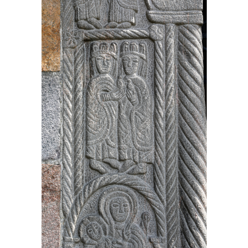 wearing very ornate robes and each holding a bird(?) -- formerly the south portal of the medieval church