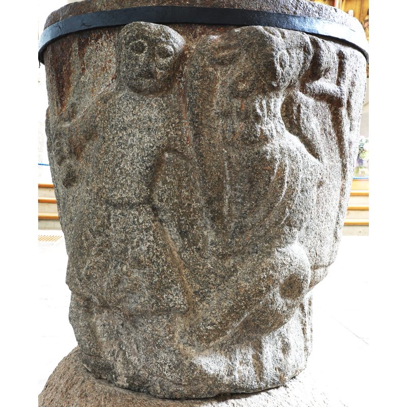 on the narrow west side of the font -- the man on the left fights the mythical beast, upper half feline, lower half reptilian; the beast devours a human that clings to a tree
