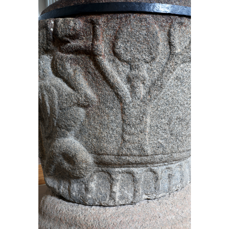 The lion bites the head of the figure who holds his arm to a branch of a Tree of Life (?).