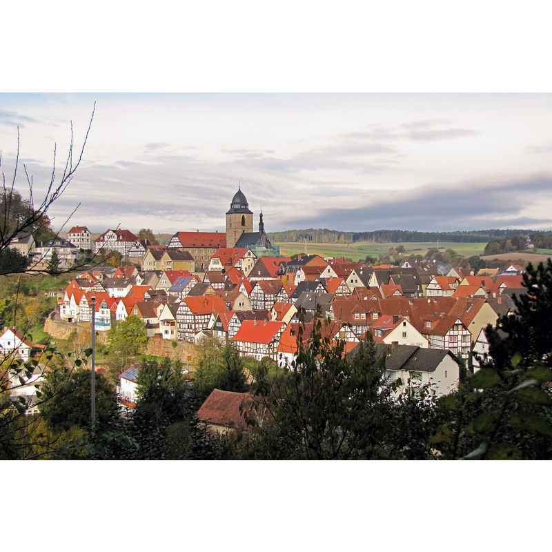 Source caption: " Blick über den Historischen Ortskern von Naumburg (Hessen) nach Westen. In der Bildmitte die katholische Stadtpfarrkirche St. Crescentius / Westward view of the historic inner city of Naumburg (Hesse). In the centre of the picture is the Catholic city parish church St. Crescentius."