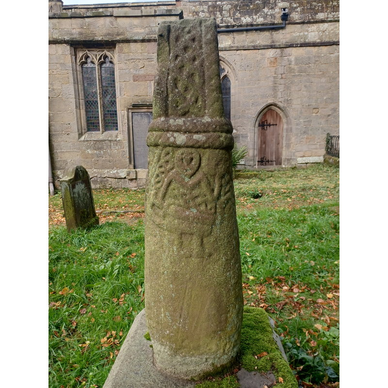 Source caption: "Anglo-Scandinavian cross shaft depicting a Viking warrior, Brailsford churchyard. Possibly a memorial to the person depicted. Early 11th century, scheduled monument. Churchyard of All Saints' Church, Brailsford, Derbyshire, England."
