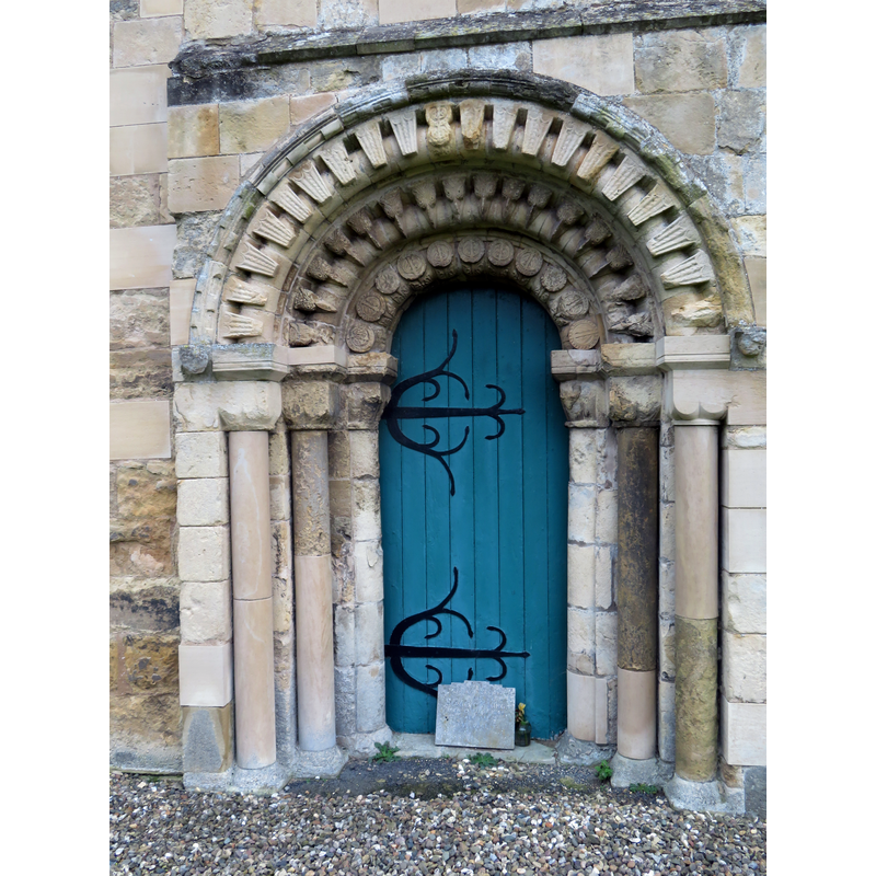 Source caption: "St Mary's church, west door. The west door at the base of the tower looks Norman in style, but how much of it is 12th century and how much is Victorian restoration? To quote Pevsner & Neave [Buildings of England, Yorkshire East Riding] - 'a restored west doorway of three orders, with scalloped capitals and an arch with orders of beakhead and a kind of abstract beakhead'. This contributor came away none the wiser."
