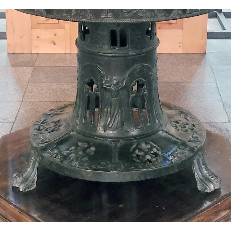 on the stem of the base, between the arches