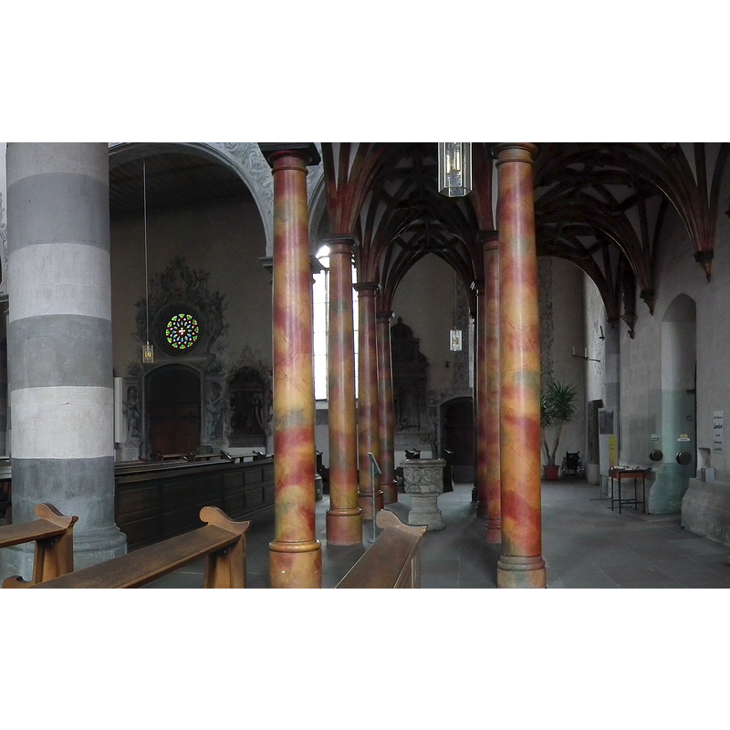 showing the former baptismal font of 1493 now re-purposed as holy-water stoup near the west entranceway