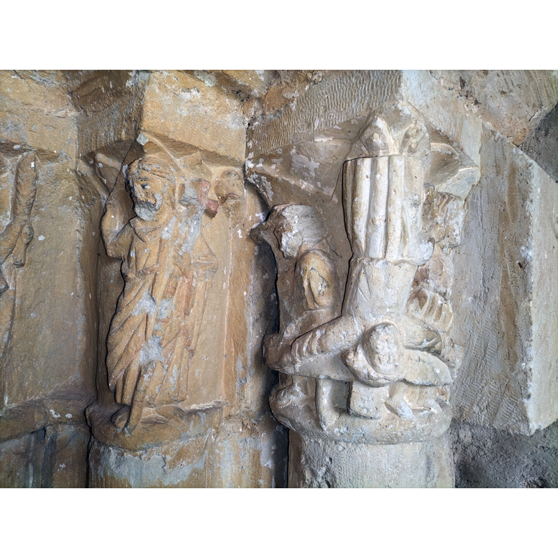 Source caption: "Saratsu - San Andres eliza - Atariko kapiteletako irudiak" -- two of the historiated capitals of the south portal; the one on the right could be the crucifixion of St. Peter