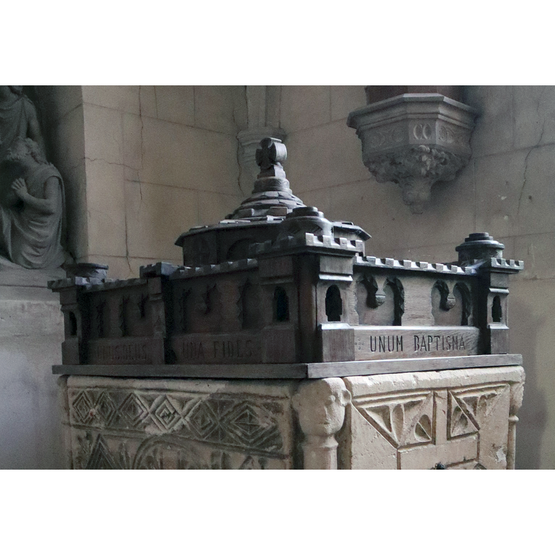 the massive castellated font cover, showing an inscription on the sides: "UNUS DEUS / UNA FIDES / UNUM BAPTISMA"