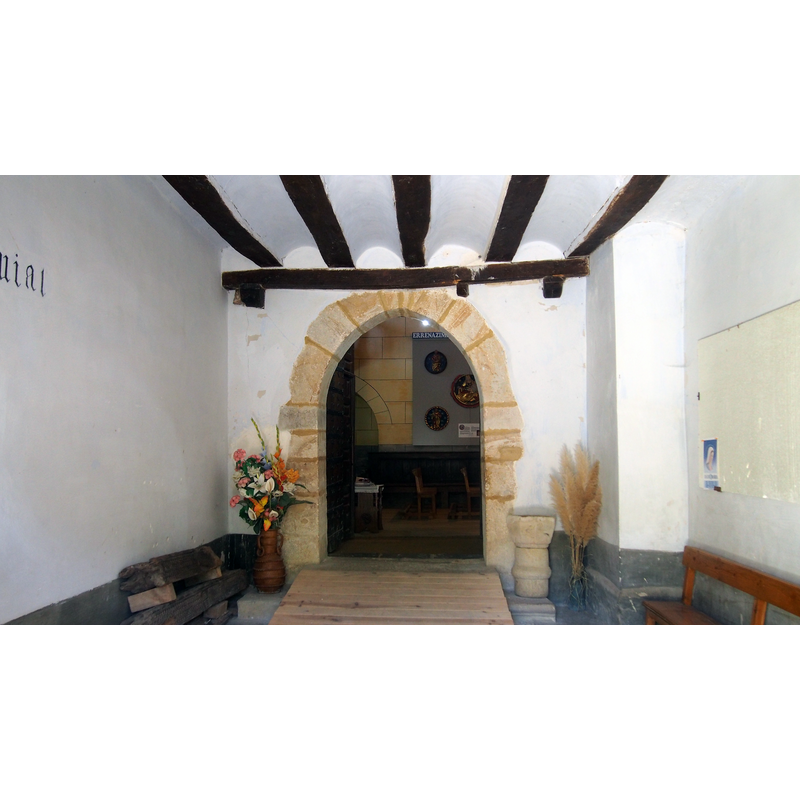 Source caption: "Domaikiako San Bartolome elizara sartzeko sarrera" -- showing the holy-water stoup on the right