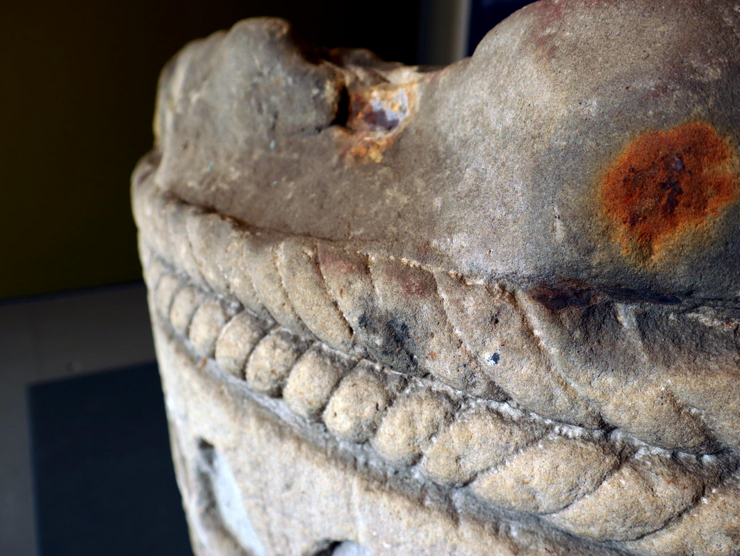 showing the motifs and the damage on the original font in the museum