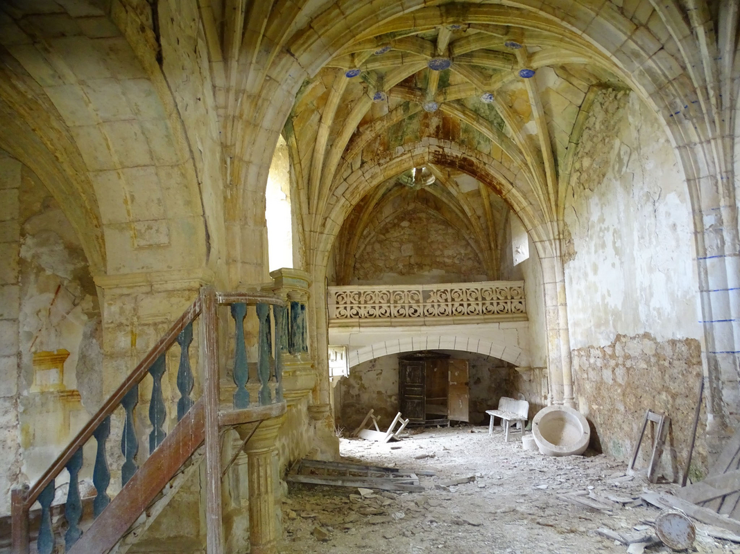 showing the disastrous state of the disused church now; the basin of the font can be seen in the bottom-right corner of the image