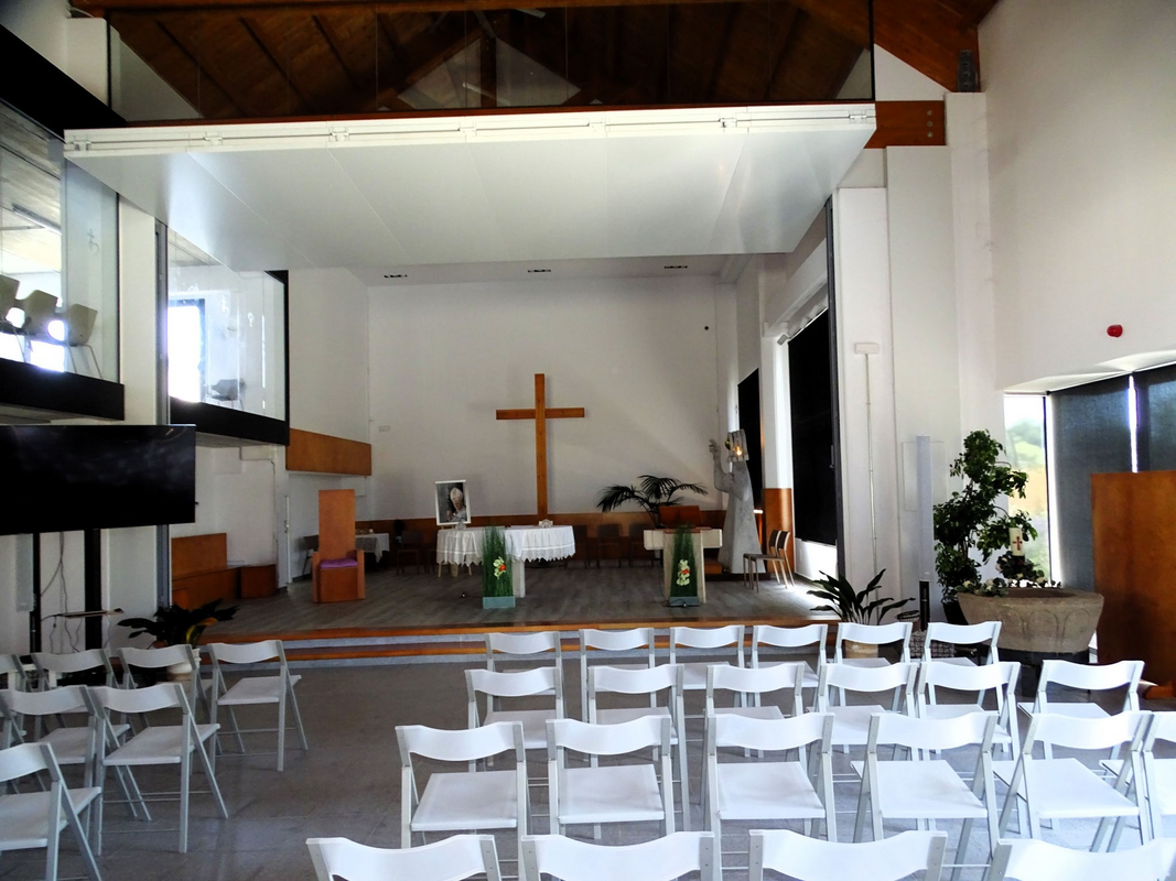 showing the old basin now installed on a modern metal base, standing in the right area of the chancel of the modern church