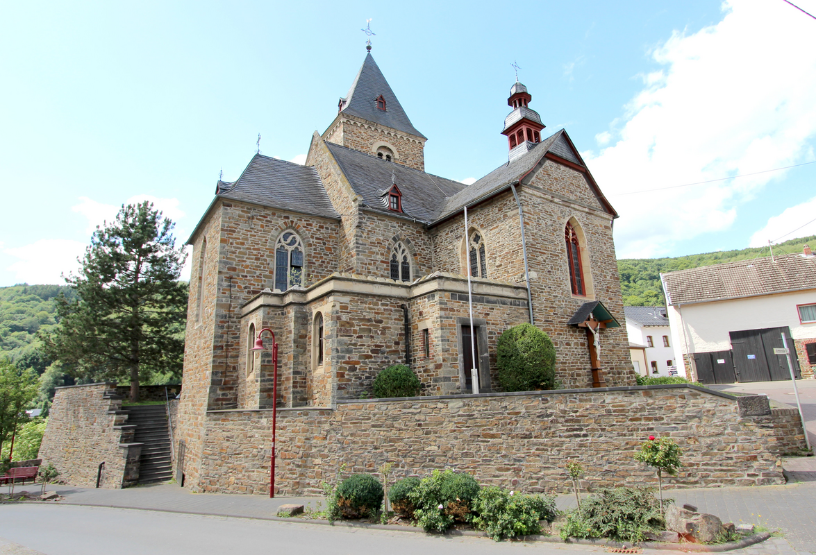 "53506 Hönningen, Kirchstraße 3. Untergeschoss des Westturms und untere Mauerpartien des Chors aus der ersten Hälfte des 13. Jahrhunderts, Chor 1494 erhöht, 1508 verändert, zweischiffiges Langhaus, 1524, Querschiff des neugotischen Bruchsteinsaalbaus, 1884/85, Architekt Lambert von Fisenne, Gelsenkirchen. Aufnahme von 2017."