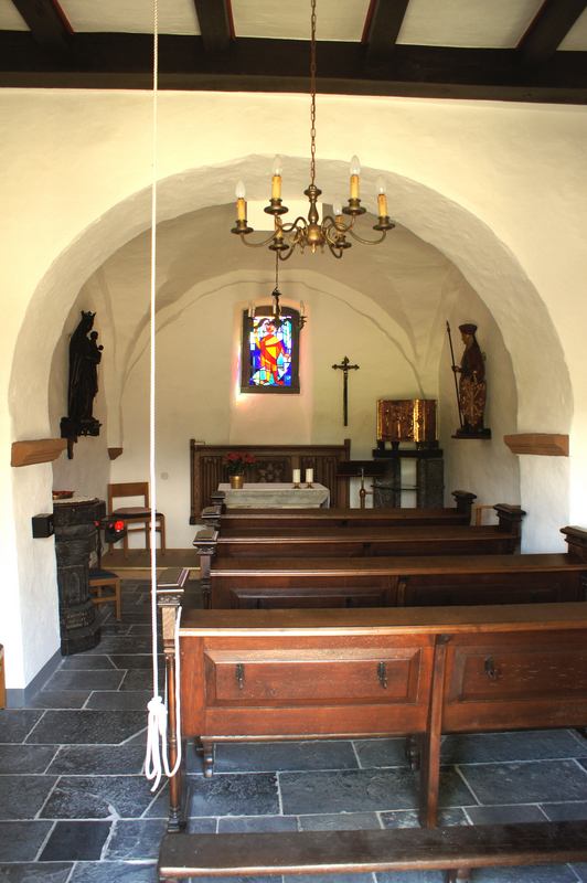 "Konzen Pankratius Kapelle Innenraum" -- the font is partially visible behind the left [north] pillar of the chancel arch