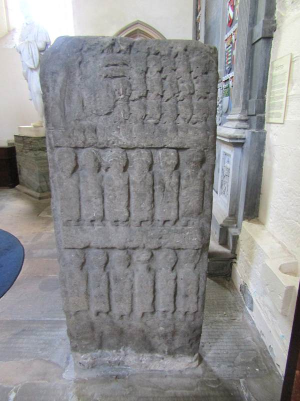 the so-called "Apostles' stone" -- "Pictish cross slab, Dunkeld Cathedral. The rear of this broken cross slab is almost filled with two figurative panels. Each panel depicts six robed and heavily weathered figures. It is postulated that these figures represent the Apostles and the larger figure on the side of the slab is Christ." [text source: Gwen and James Anderson [https://www.geograph.org.uk/photo/1351769] [accessed 1 March 2026]]
