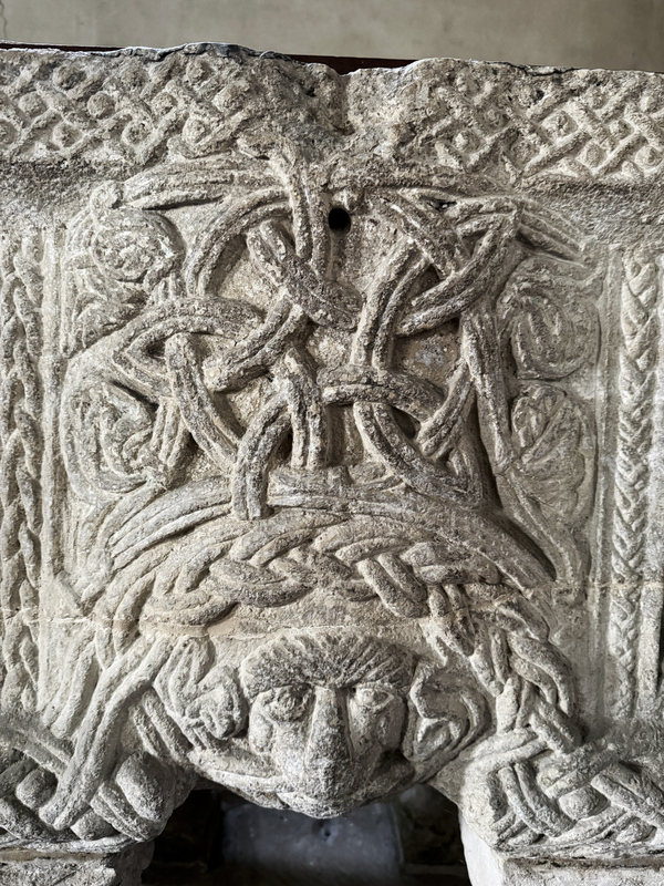 notice the pattern below the upper rim, and the damage showing the hole left from the font cover anchoring now gone -- vertical braided strips on the side of the complex 2-strand interlace