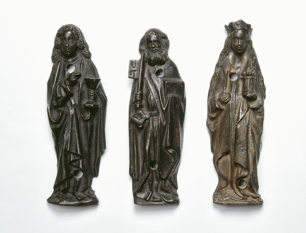 "Three figurative reliefs, depicting St. John the evangelist (original), St. Peter and St. Barbara (cast). Bronze, 1497. From the baptismal font of Dionysius church in Debstedt (Germany). Now in the Focke-Museum, Bremen / Drei Figuren aus Bronze vom Taufbecken in Debstedt, jetzt im Focke-Museum Bremen, Inv.Nr. 1988.062. Johannes der Evangelist ist ein Original, der Hl. Petrus und die Hl. Barbara sind in den 1930er Jahren angefertigte Abgüsse."
