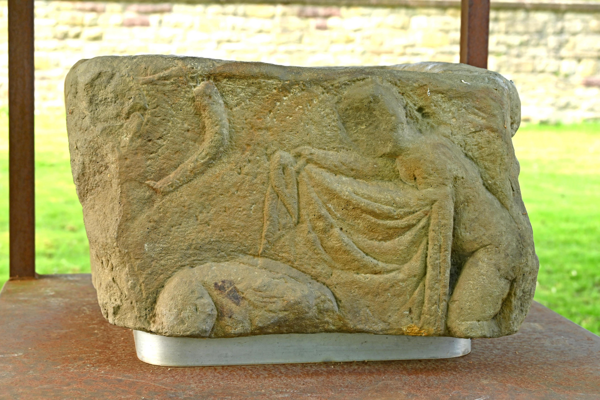 "Dudeldorf, Abguss eines römischen Grabmalquaders mit zwei Reliefs: eine Jagdszene und die Szene einer Weinlese, 1910 im Hof des Pfarrhauses als Taufstein entdeckt" -- cast of a Roman tombstone block with two reliefs: a hunting scene and a grape harvest scene, discovered in 1910 in the courtyard of the rectory -- was it used as a baptismal font?