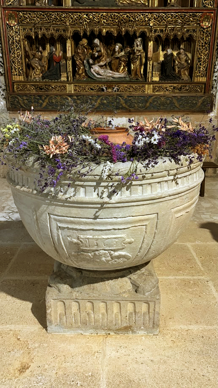 the lower part of the 15thC Flemish retable is visible behind the font 