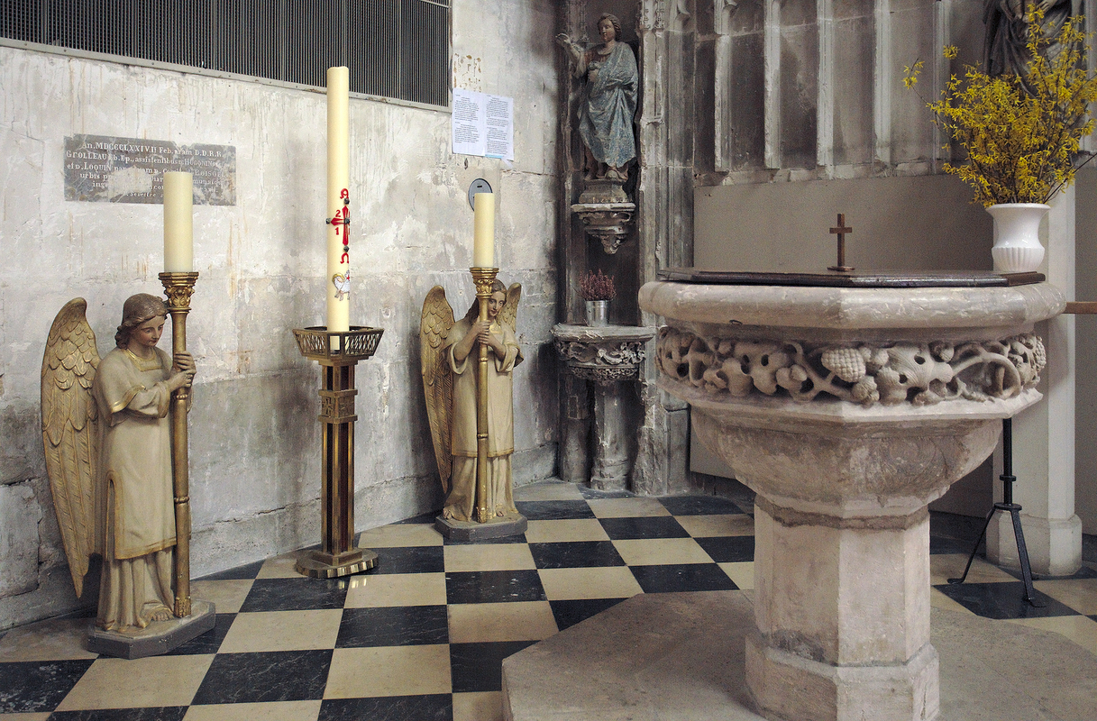 "Church interior of the Saint Nicolas church in Beaumont-le-Roger, Eure, Normandie, France." -- showing the stoup in the background, left corner