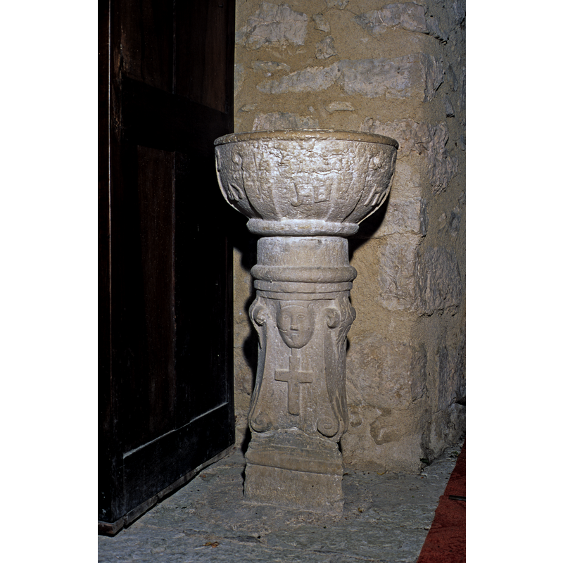 a head and a cross; notice the possible connection with the figure on the baptismal font