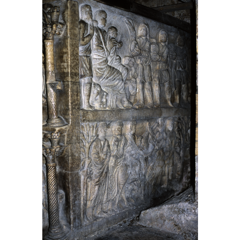 the left side is towards the east; the front faces south -- this side has two registers clearly separated by the frame -- the columns visible on the left sides, up and down, are from the front arcade
