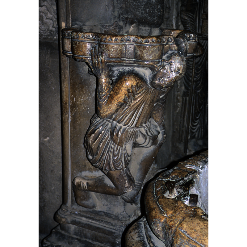 right arm supports the basin, left hand rests on his knee