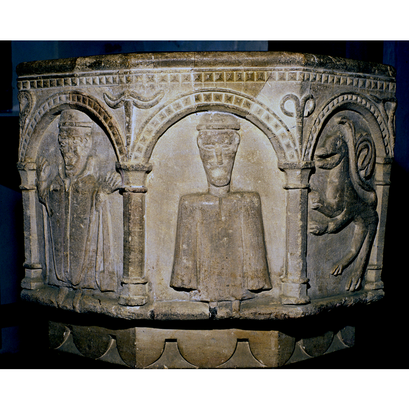 appears to the right of the hooded man, to the left of the caped crowned (?) figure