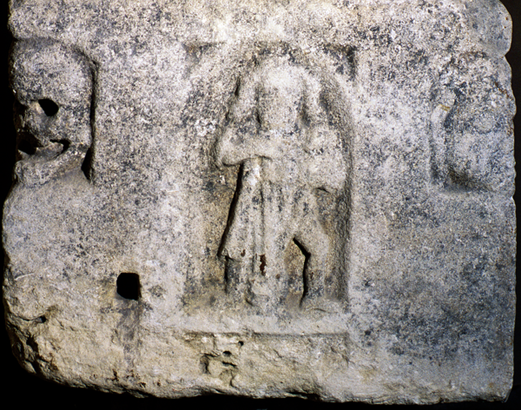 the decapitated figure holds his head in his left hand, as if it were a helmet