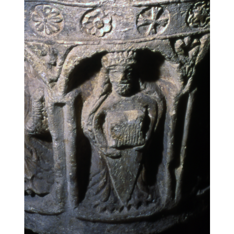 is he crowned? what is the object held in both arms?