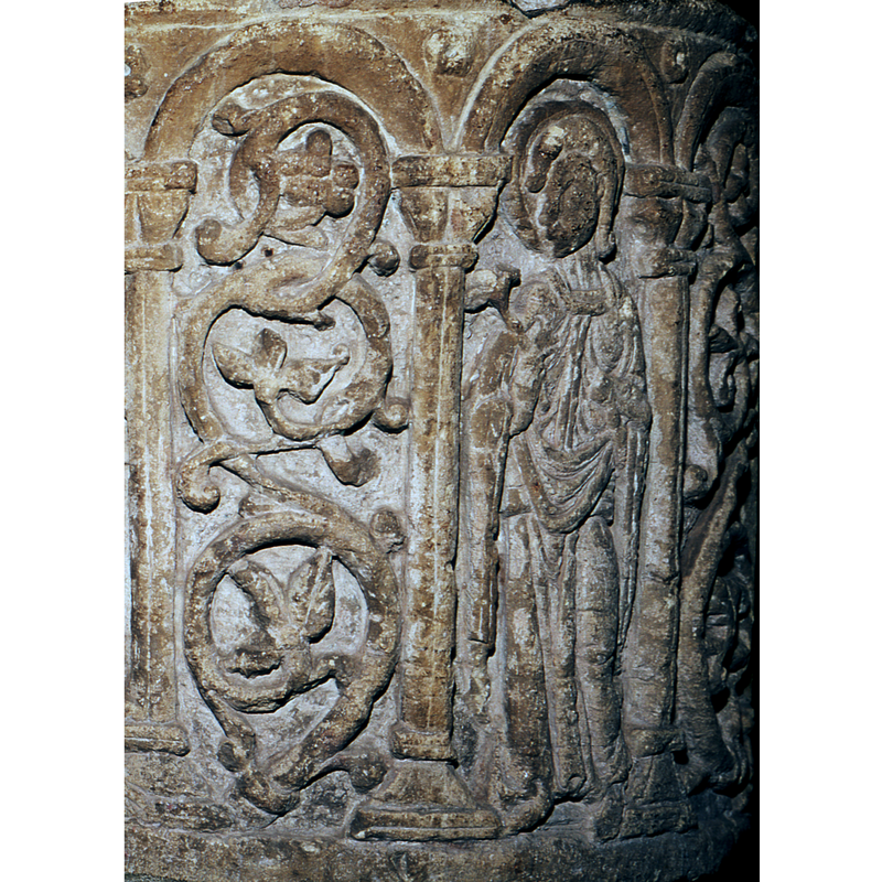 The figure has long hair or braids.  (St. Mary Magdalene?)