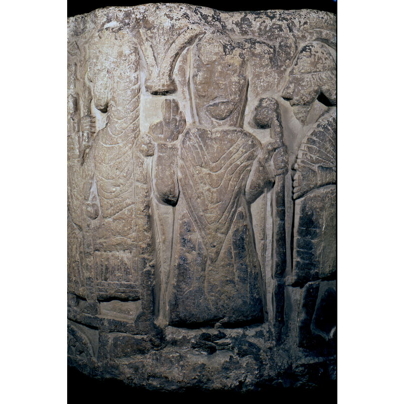 Upper part of the head is broken but he appears to be a bishop, left hand holding the staff and the right raised in benediction