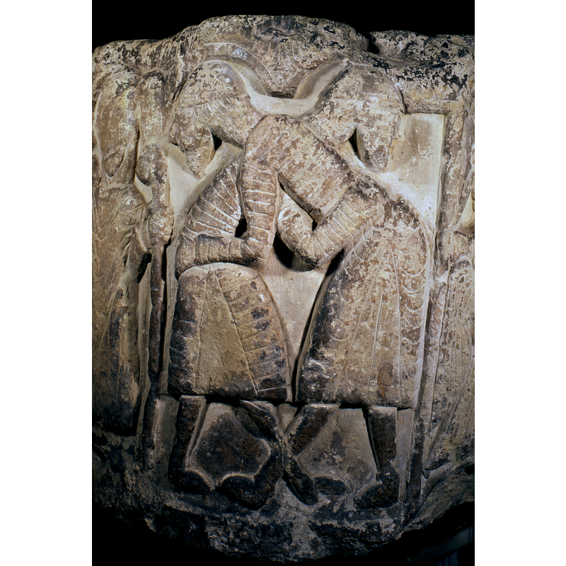 The two figures are engaged in a hug; the position and the clothes indicate that they are wrestlers [cf. Home (1908) in Font notes]