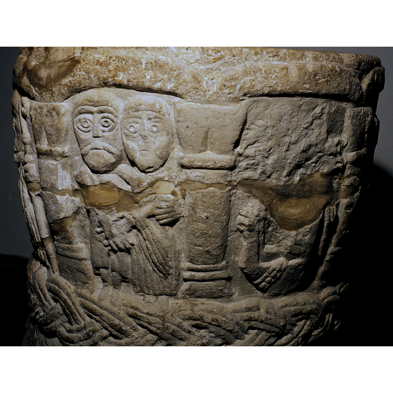 In 1997 there was a fire which destroyed much of the church and part of this section on the font. Some have identified the animal at the top as an elephant; the animal below appears to be on the side or upside down; there is a broad column between the animals on the left and the archer on the right but the tip of the arrow is between the column and the viewer