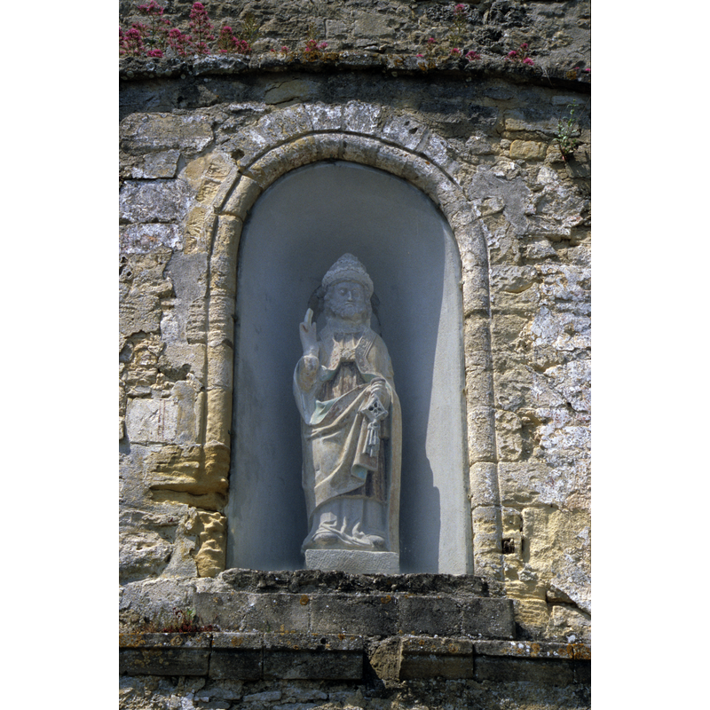 a statue of the patron saint of the ruined church in a niche of the side of the tower