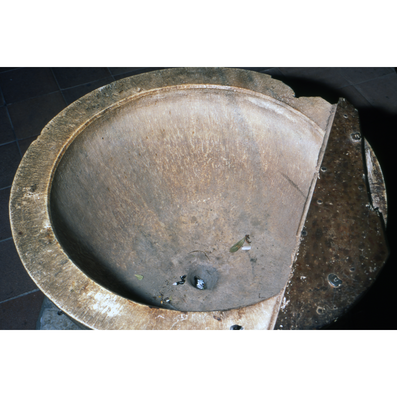 showing the centre drain, some of the damage to the upper rim by metal anchorings of earlier font covers, and a fragment of a relatively modern lid still attached to the basin top
