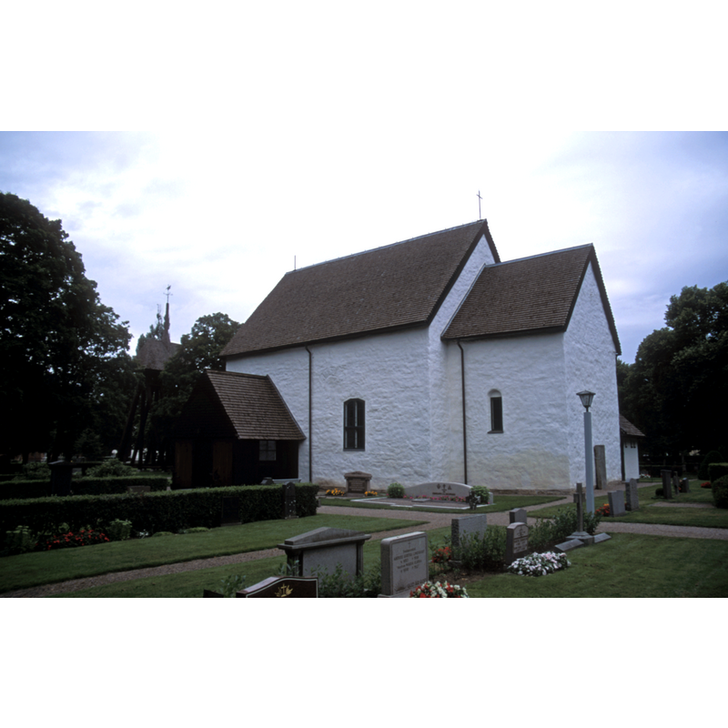 the roof and 'legs' of the bell tower are partially visible on the left, among the shrubbery