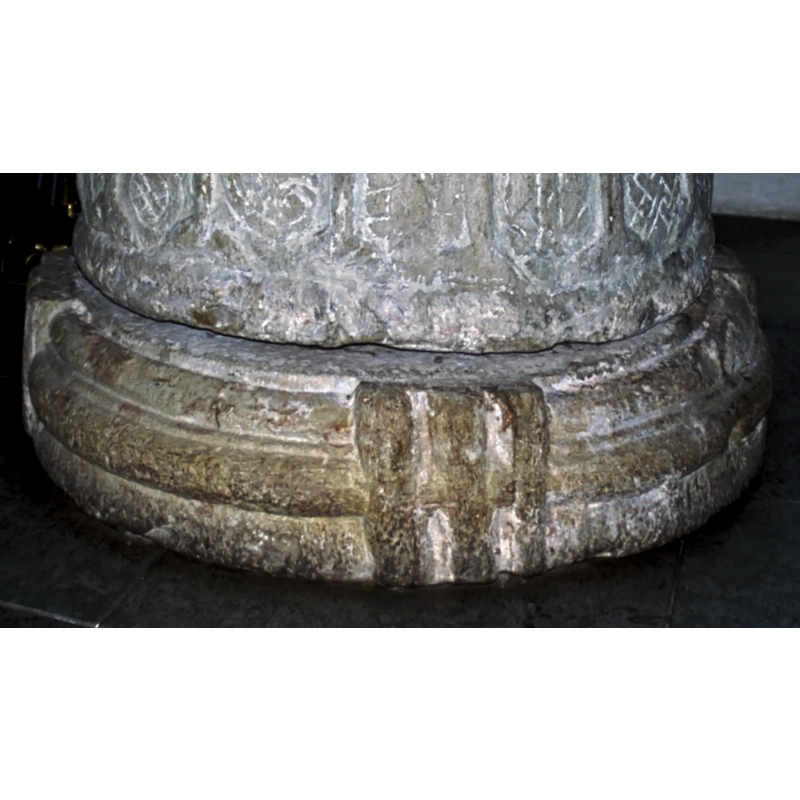 simulating a reinforcing band around the squat lower base; the central moulding may be the body of a reptile