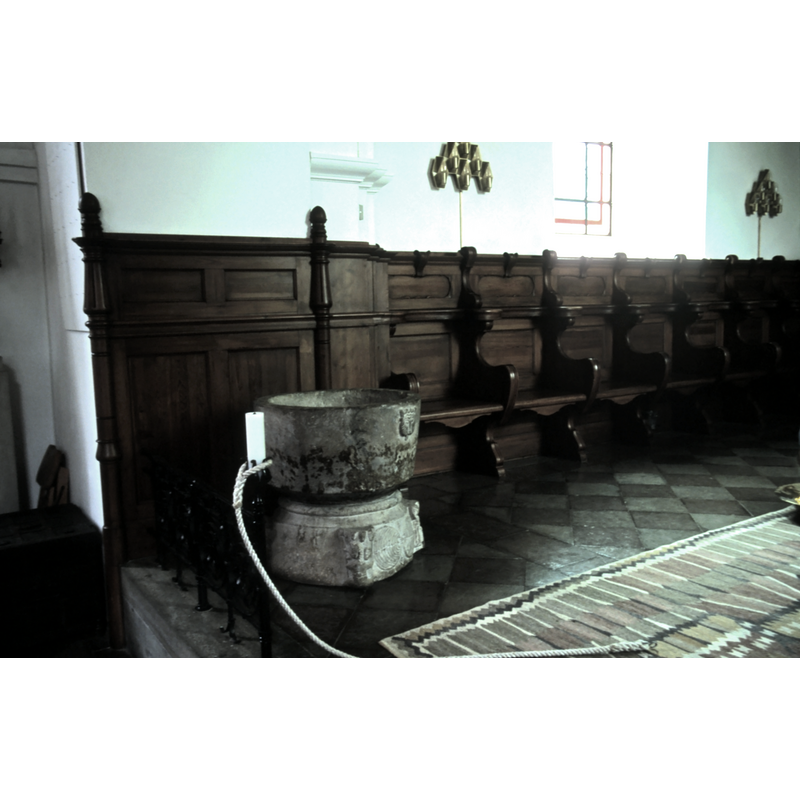 by the choir pews, at the east end of the nave