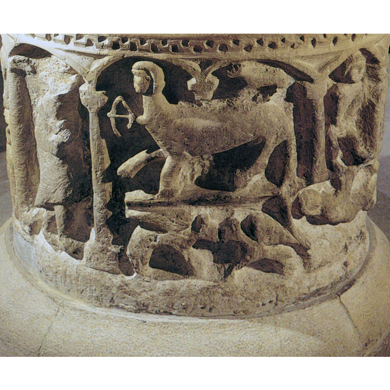 Centaur in the right arch points his arrow at an armed warrior in the previous arch; there is a small quadruped on the standing on the rump of the centaur; in the lower half of the frame are two winged quadrupeds facing each other in a fight, by all appearances; the centaur occupies two arches and the support between tham has been left out, as often happens in these occasions
