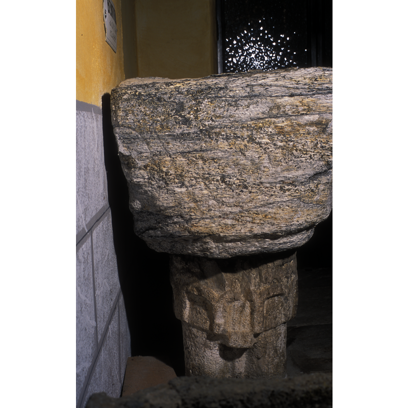 at the top of the pedestal of the base, in very high relief