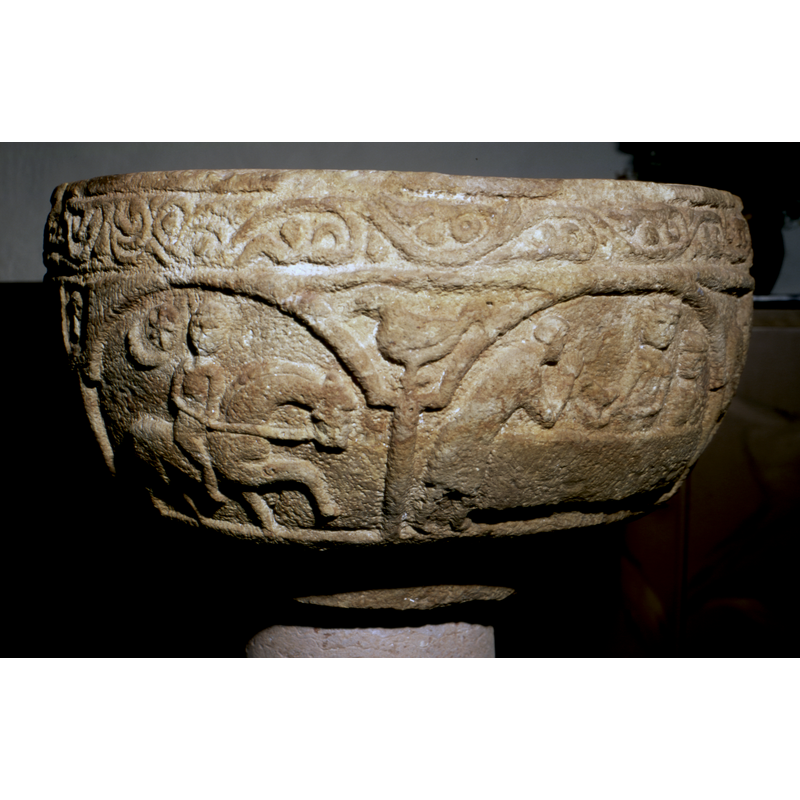 He rides on a horse in the night; a moon and star by his shoulder -- seen here in the left arch