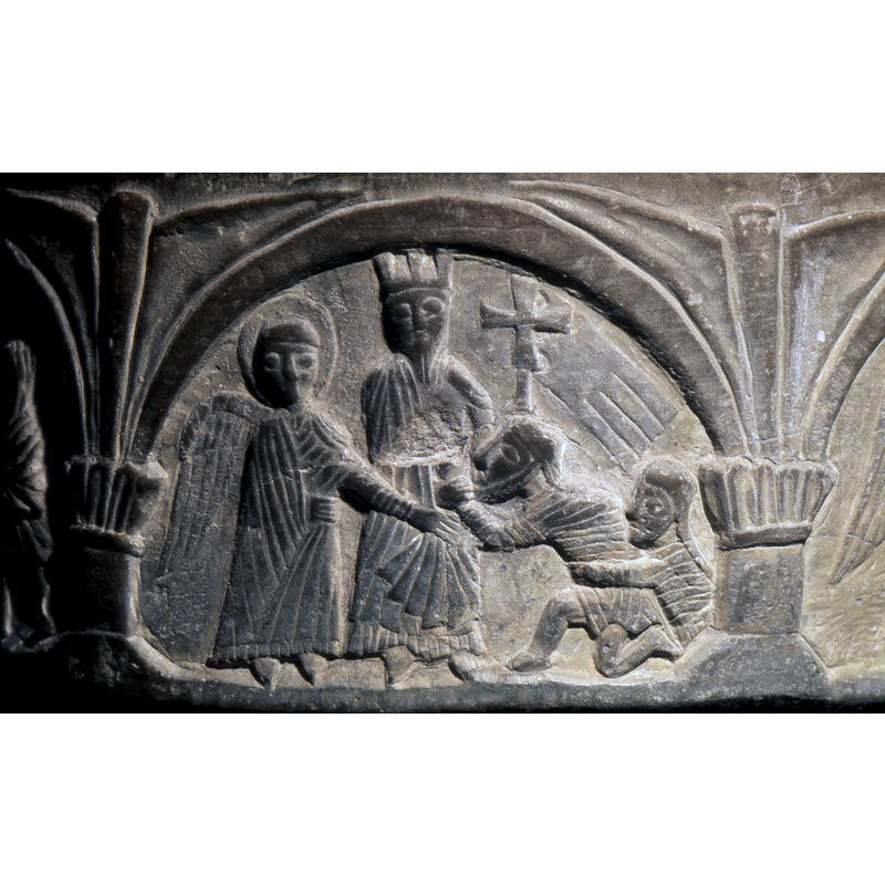 Harrowing of Hell. In the centre, Christ, crowned, in his left hand holds a cross on a staff, his right hand under the coat, holds the wrist of the figure on the right. The figure (male - bearded) is held by the waist by a female figure. To the left an angel haloed reaches with his right hand to the figures to the right. -- Photographed in June 1997