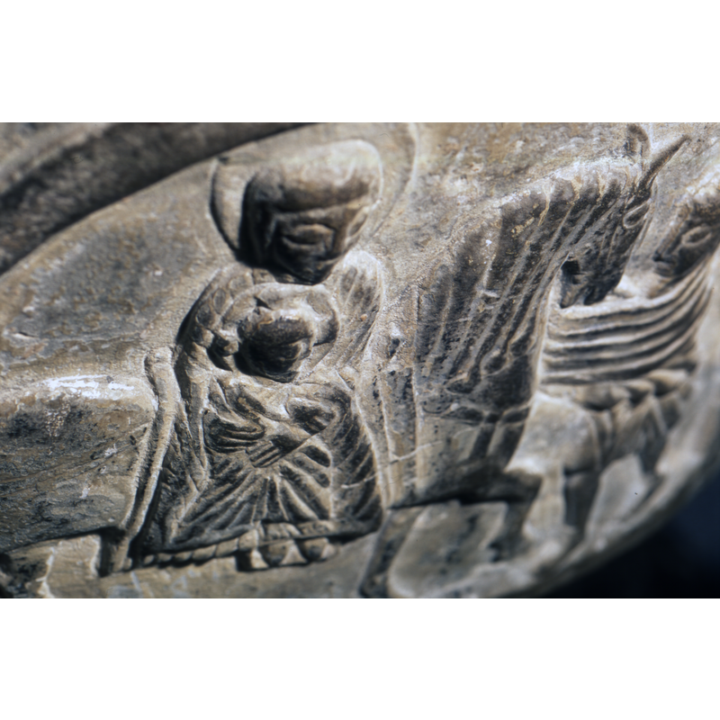 Flight to Egypt. Madonna and Child, sit on a large horse, richly appointed, Madonna full front, haloed with headdress, holds child. Child full frontal and looks to the right is haloed with cross. Joseph faces the left, holding the horse, wears a short tunic, and wears a conical hat - hood.