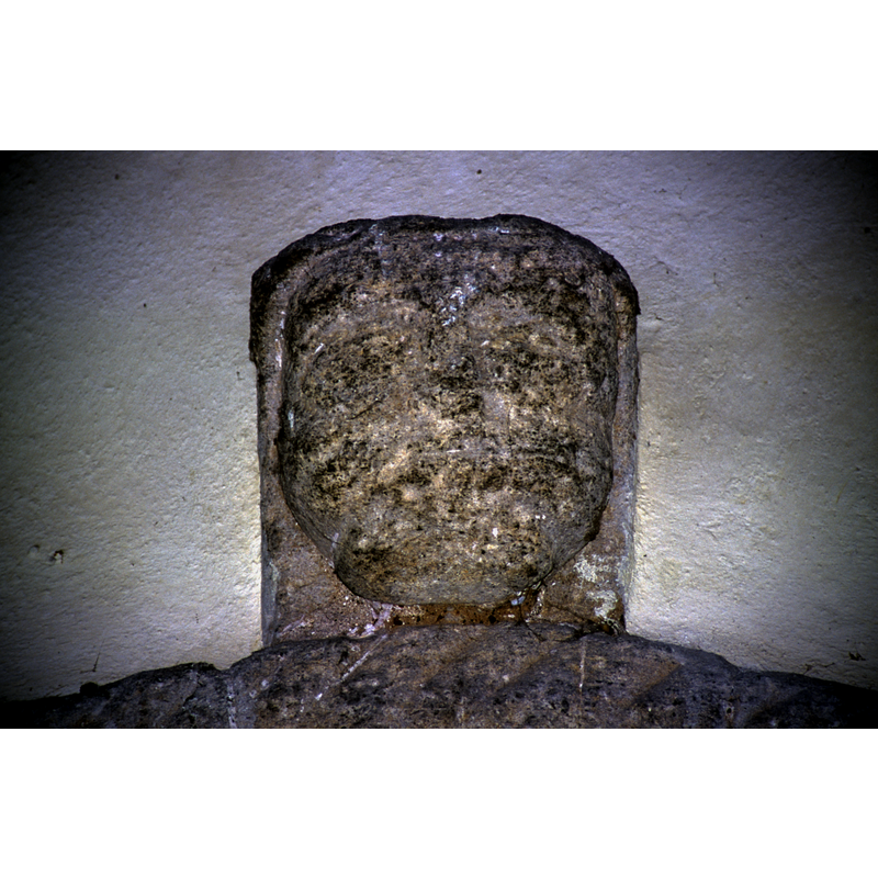 finial head atop the portal arch