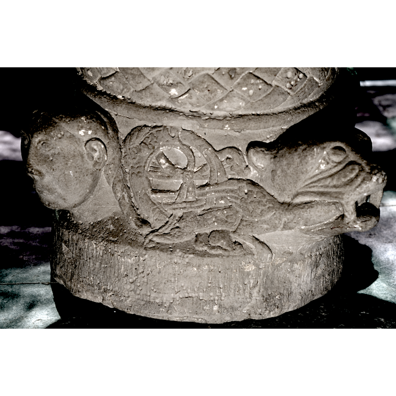the motif on the side of thew base, between the heads, is a very complex one; as ssen here, the braid of the human figure on the left becomes an interlace which resembles the body of a snake, which in turn becomes a bird (?) caught in the mouth of the beast on the right, possibly a lion