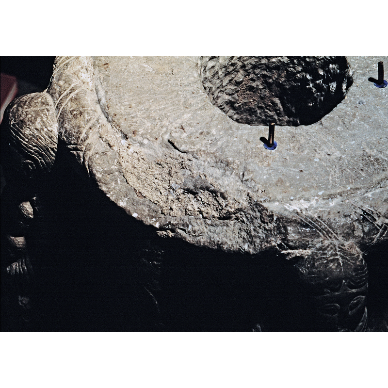 showing the damage to the top of the base, to the patterned centre ring between two of the human heads
