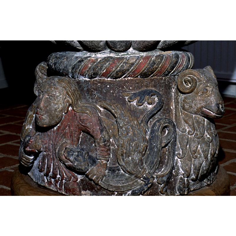 between the Great Harlot on the left and the ram on the right, a winged serpents or dragon suckles her breast
