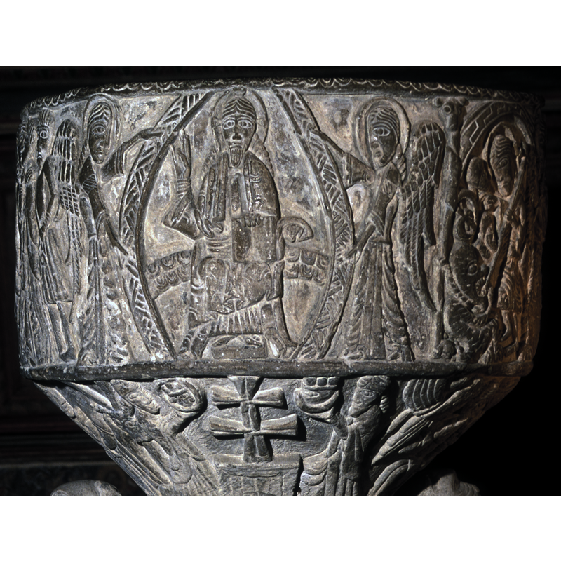 Christ in Majesty seated in a richly-decorated mandorla held by two angels standing in profile, book on his left knee, right hand raised in benediction; This scene is carved directly above the underbowl scene of the Etimasia