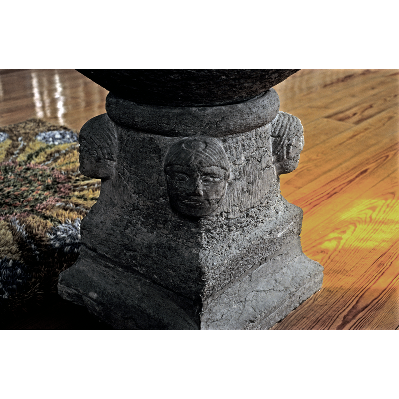 one of two tonsured heads; this one on the southwest sid of the base