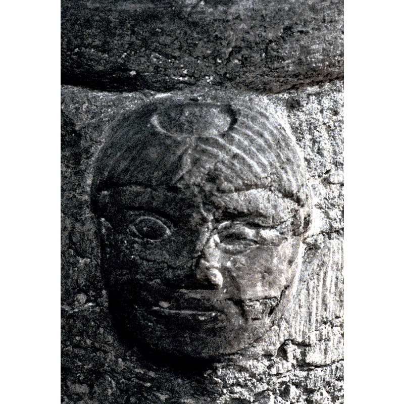 one of two tonsured heads; this one on the northeast corner of the base