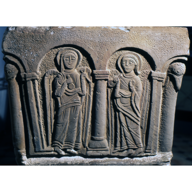 in the right arch: an angel holds in his right hand an object which looks like a spoon and left hand raised with palm open at chest level